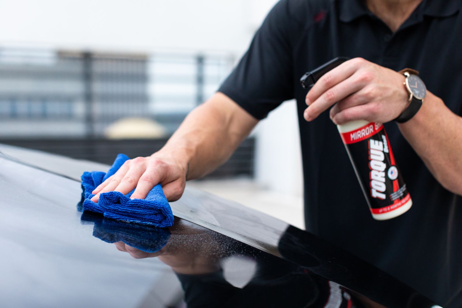 Hands wiping paint with a microfiber cloth before coating